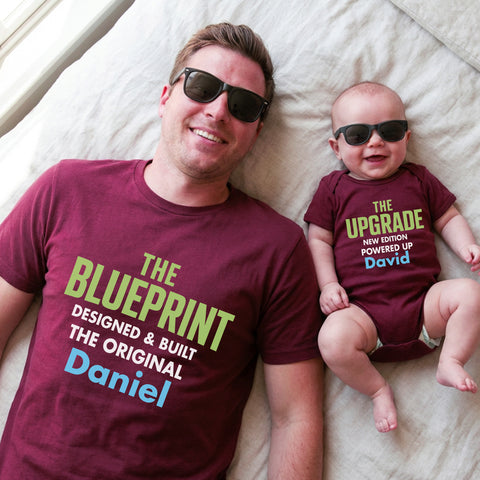 Man and baby wearing matching shirts with text on a bed